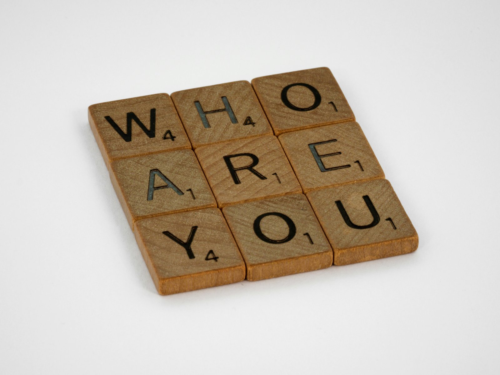 Scrabble tiles arranged to spell the question WHO ARE YOU