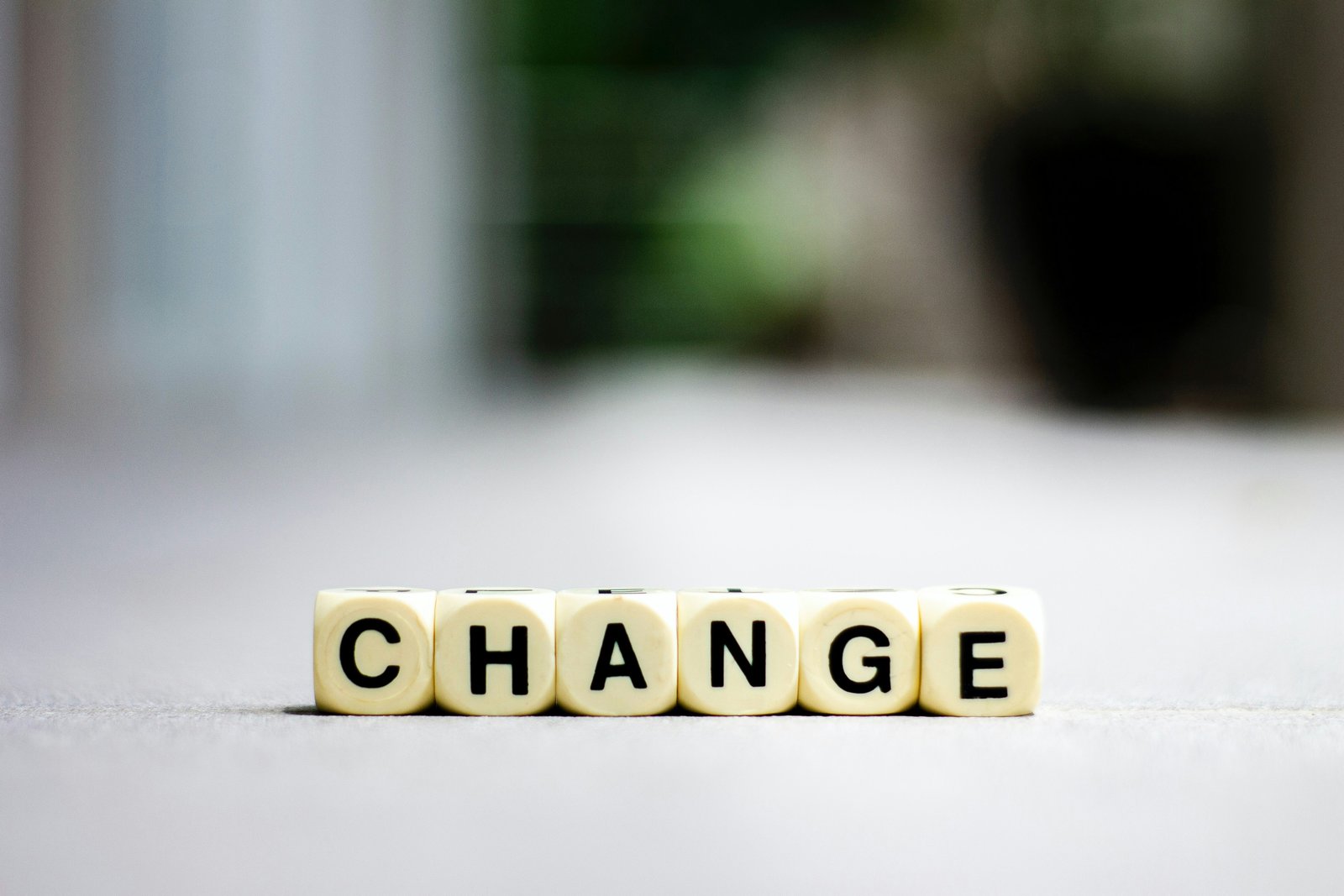 Letter dice spelling the word CHANGE on a light surface